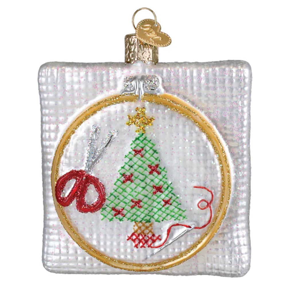Decorative Christmas ornament with embroidery hoop, scissors, and embroidered Christmas tree.