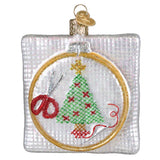 Decorative Christmas ornament with embroidery hoop, scissors, and embroidered Christmas tree.