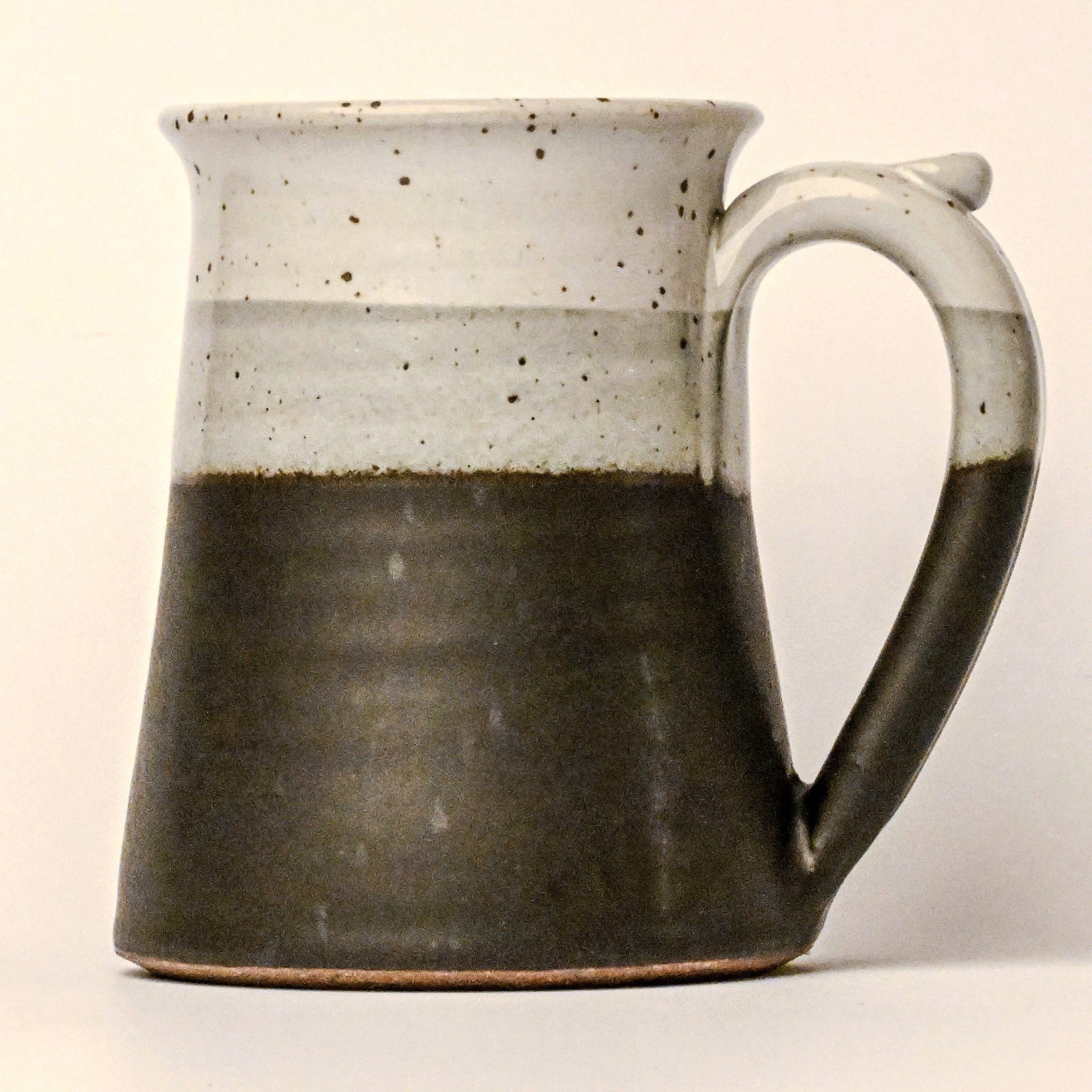 Ceramic mug with two-tone design on a plain background
