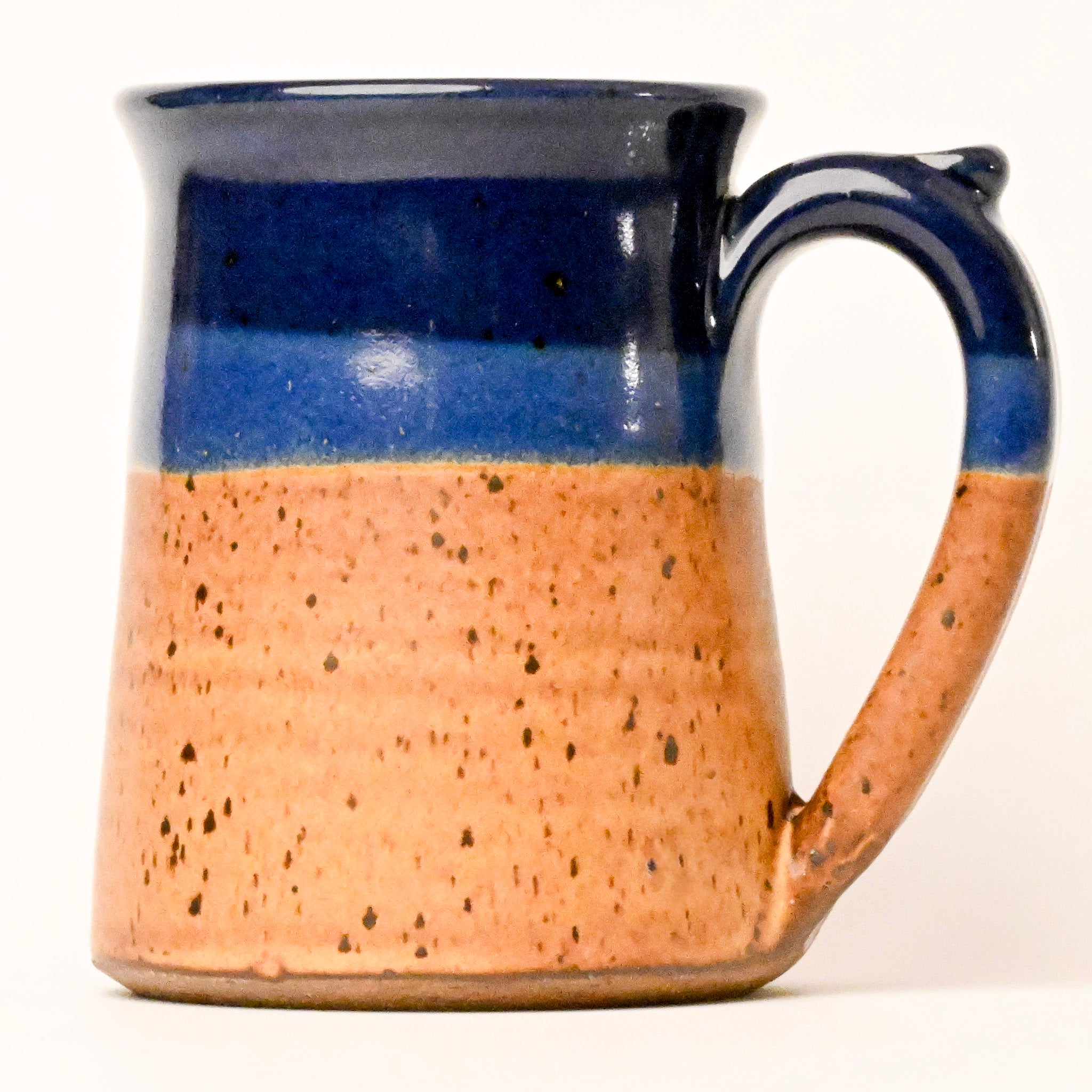 Ceramic mug with blue top and brown speckled body on a white background
