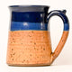 Ceramic mug with blue top and brown speckled body on a white background