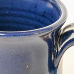 Close-up of a blue ceramic mug with a glossy finish