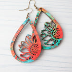 Pair of colorful teardrop-shaped earrings on a light wooden surface