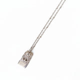 Silver necklace with a pendant on a white textured surface