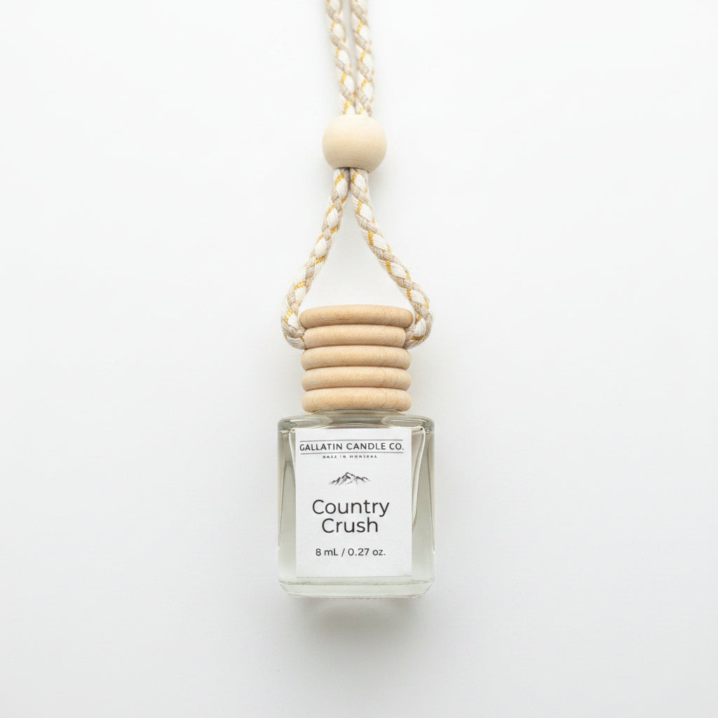 A 8 ml reed diffuser bottle by Gallatin Candle Co. in the scent Country Crush, featuring a clear glass bottle with a white label, a wooden cap, and a braided rope handle with a wooden bead, styled on a white background