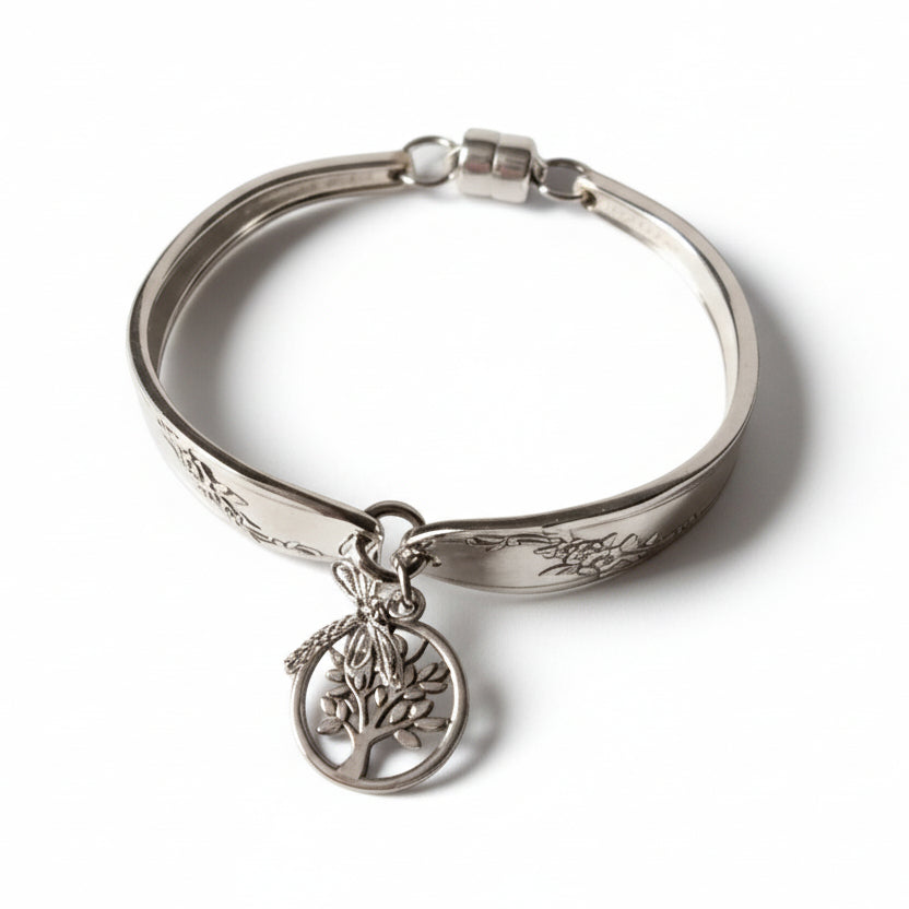 Silver bracelet with a tree of life charm on a white background