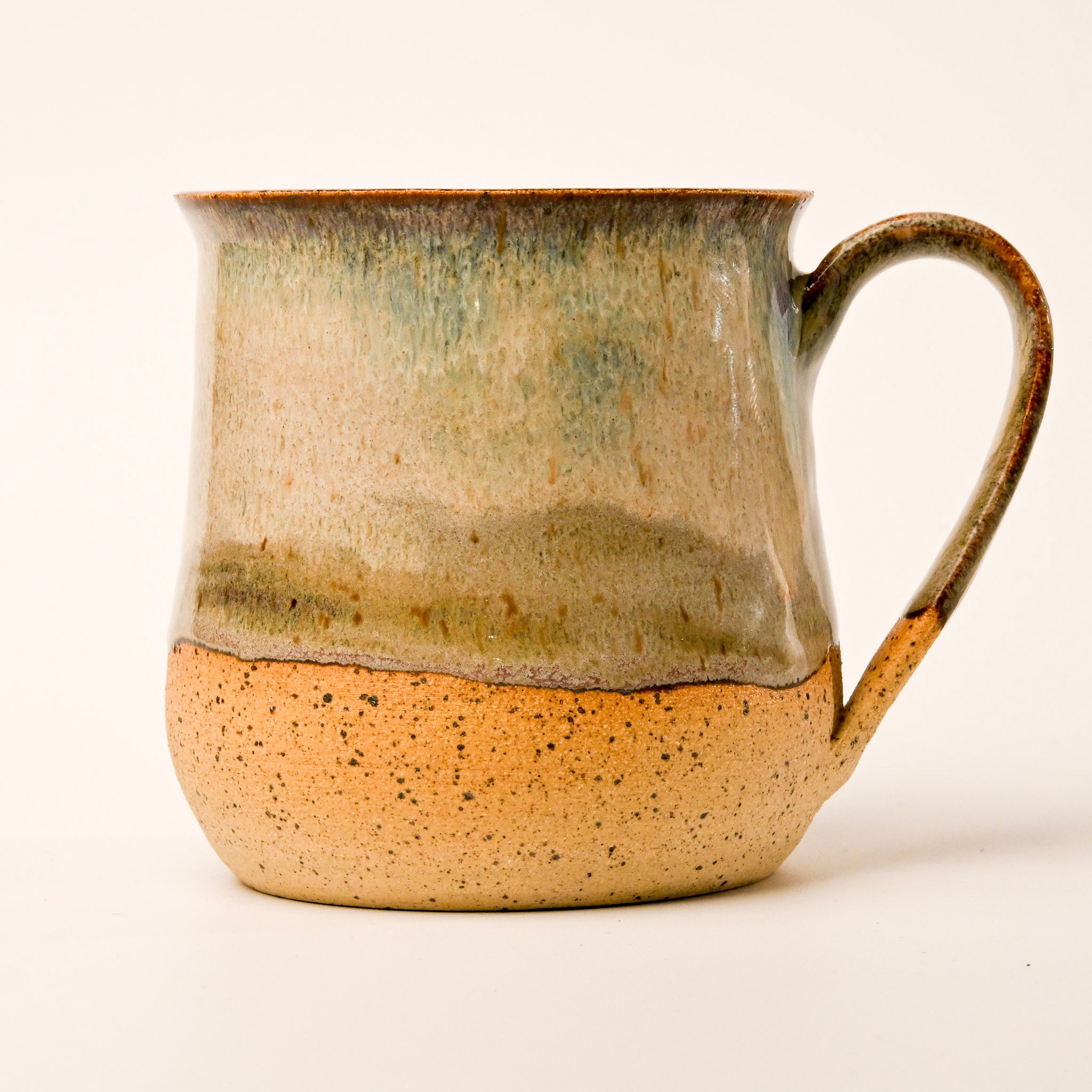 Ceramic mug with a speckled base and gradient finish on a white background