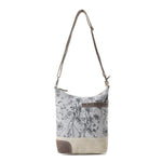 Floral patterned handbag with a strap on a white background