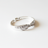 Silver bracelet with intricate design on a white background