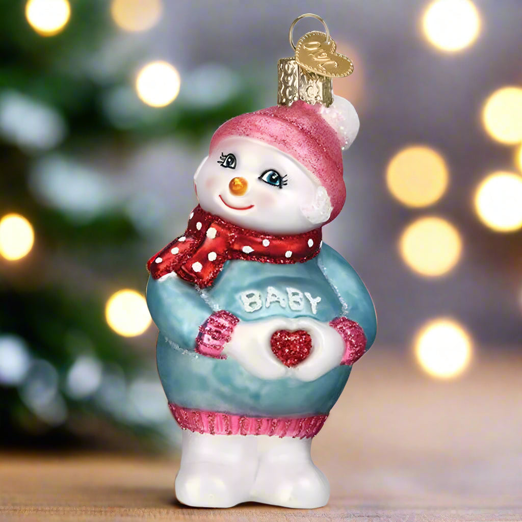 Decorative snowman ornament with 'Baby' sweater on a white background