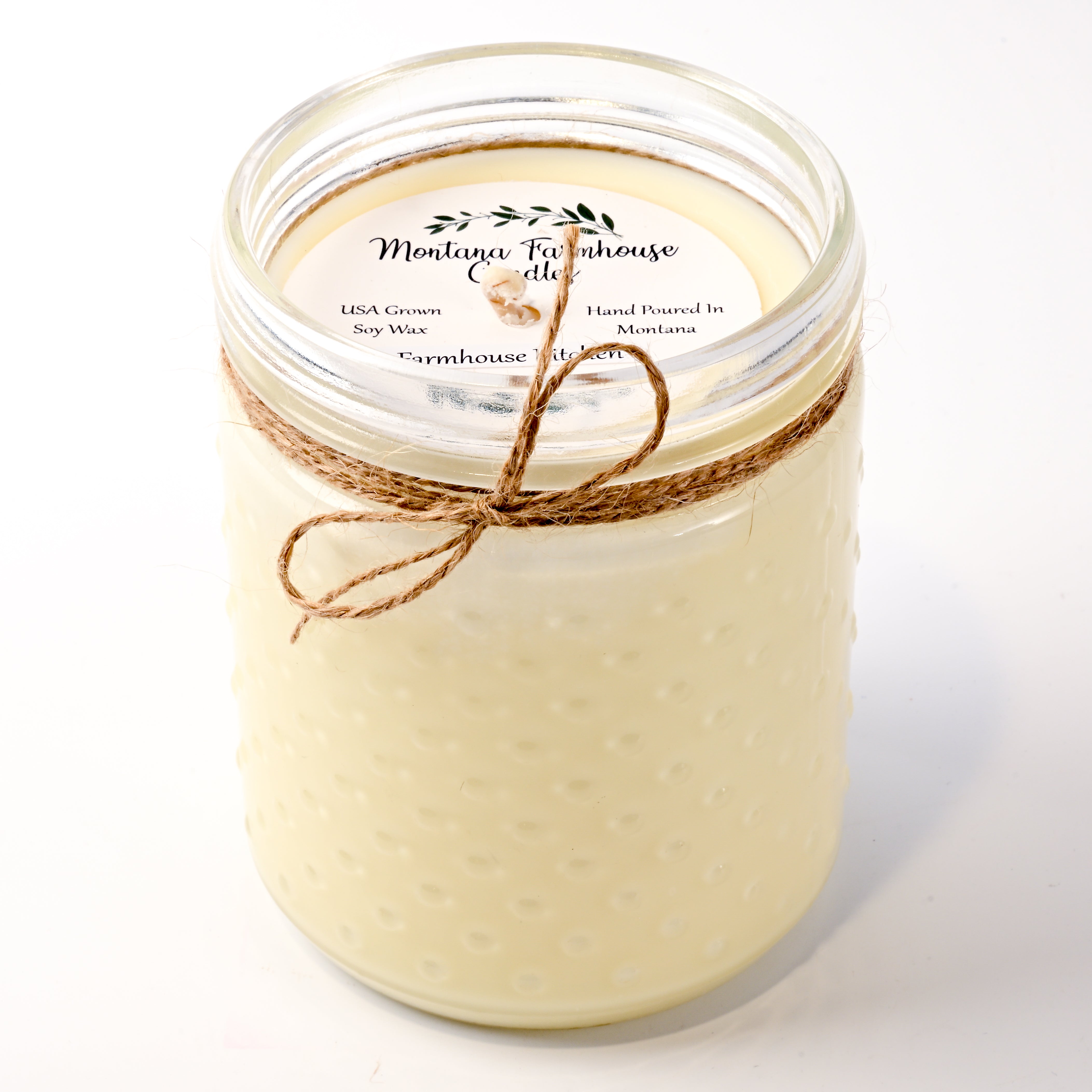 Jar candle with twine bow and 'Montana Farmhouse Candles' label on a white background