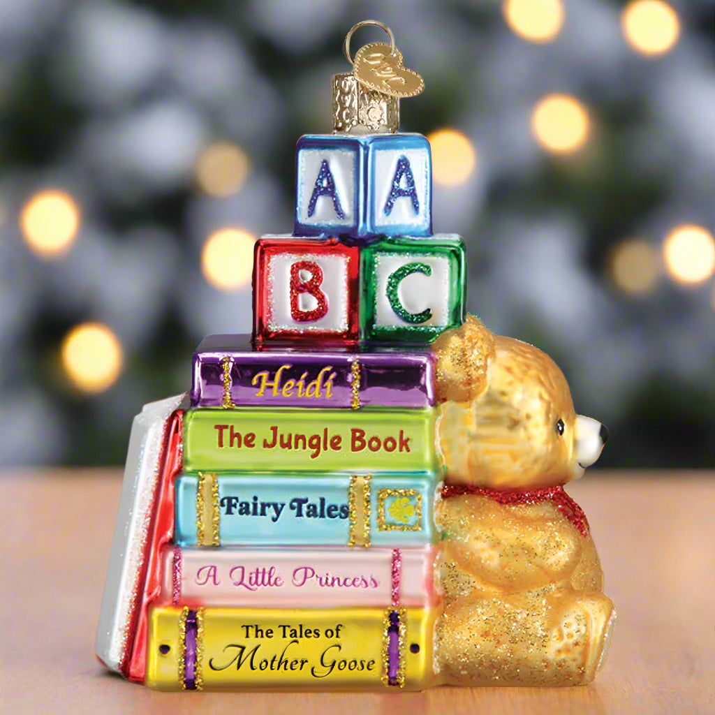 Decorative ornament with books and a teddy bear on a white background