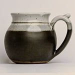 Stoneware mug with a handle on a light gray background