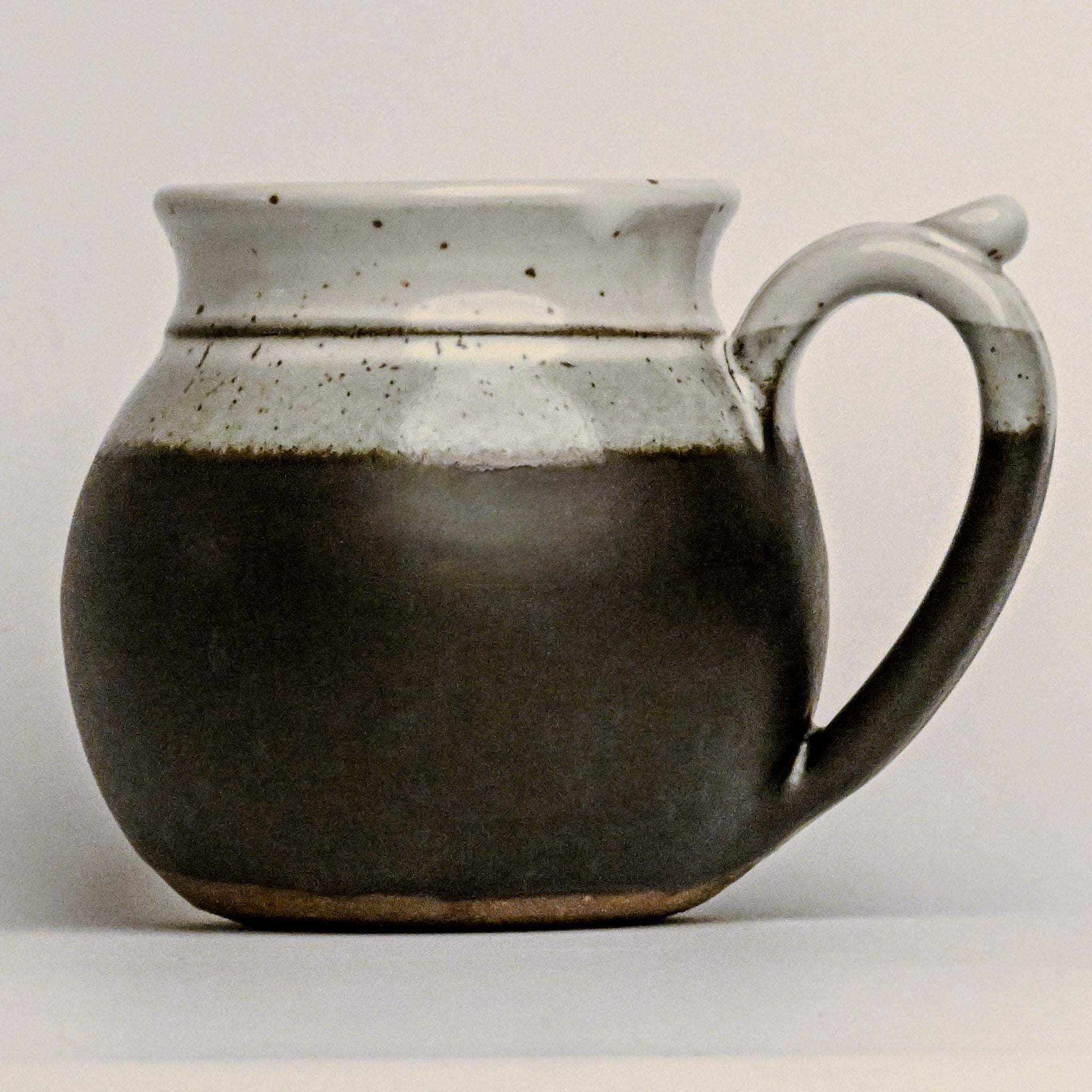 Stoneware mug with a handle on a light gray background