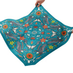 Colorful fabric with animal and floral patterns held by hands on a white background