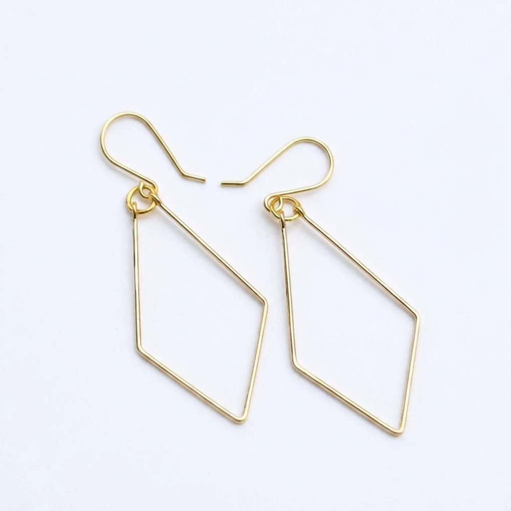 A pair of gold geometric dangle earrings with open diamond-shaped drops and fishhook backings, shown on a clean white background.