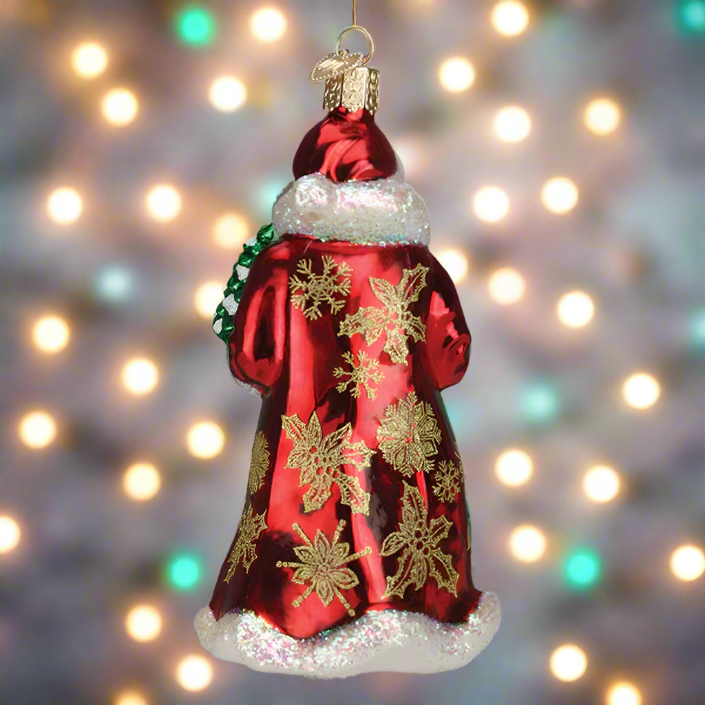 Decorative Christmas ornament of a Santa Claus figure with gold snowflakes on a red coat.