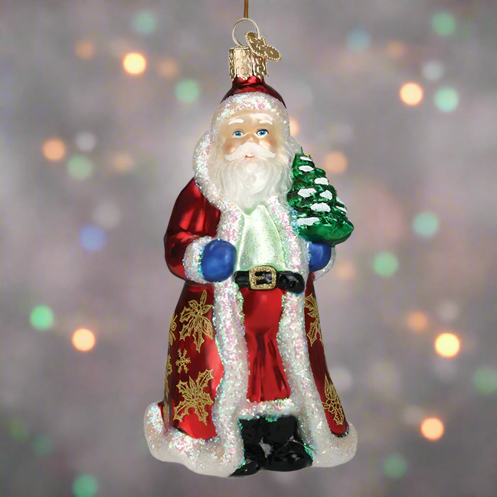Glass ornament of Santa Claus holding a tree