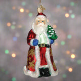 Glass ornament of Santa Claus holding a tree
