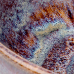 Close-up of a rusted metal surface with brown and purple hues