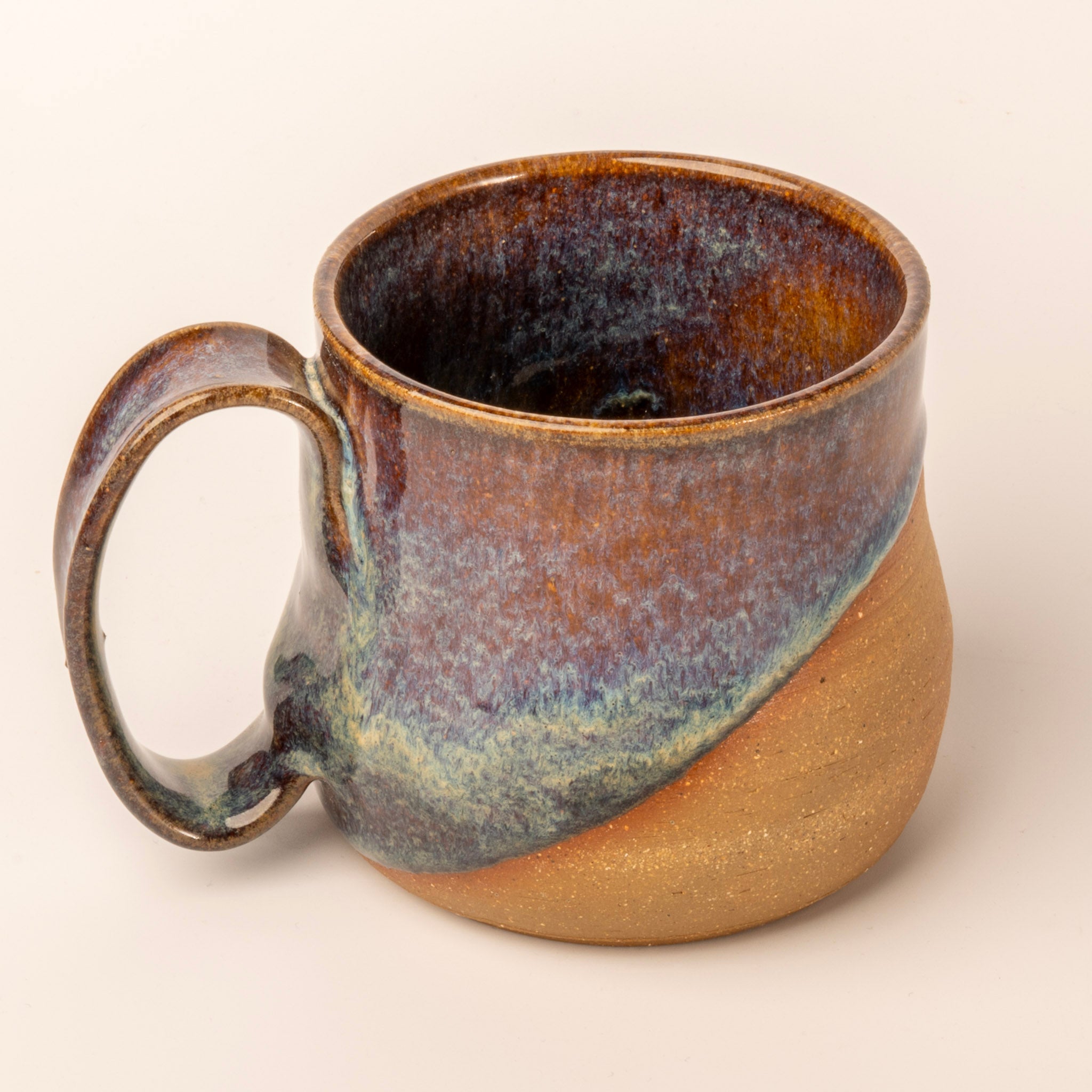 Ceramic mug with a two-tone design on a beige background