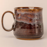 Brown ceramic mug with a textured surface on a beige background