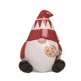 Decorative gnome with a red hat and white beard holding a small dog on a white background