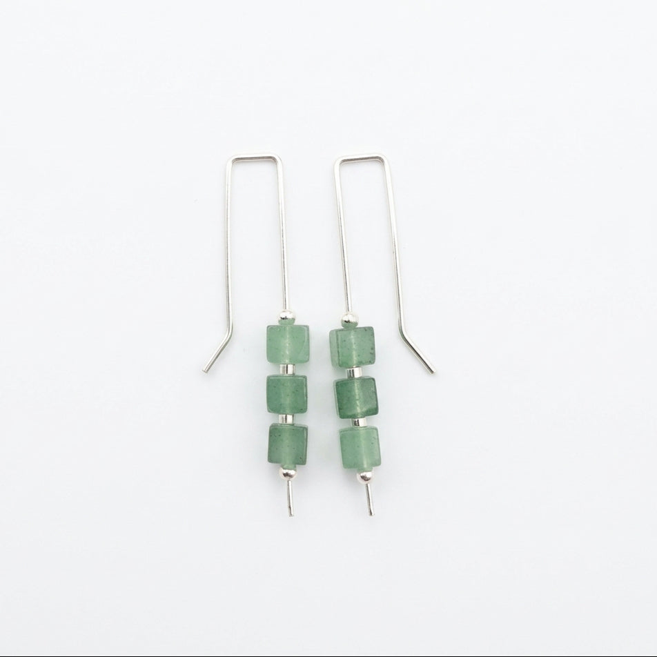 A pair of silver drop earrings with three green faceted beads on each earring, displayed on a white background