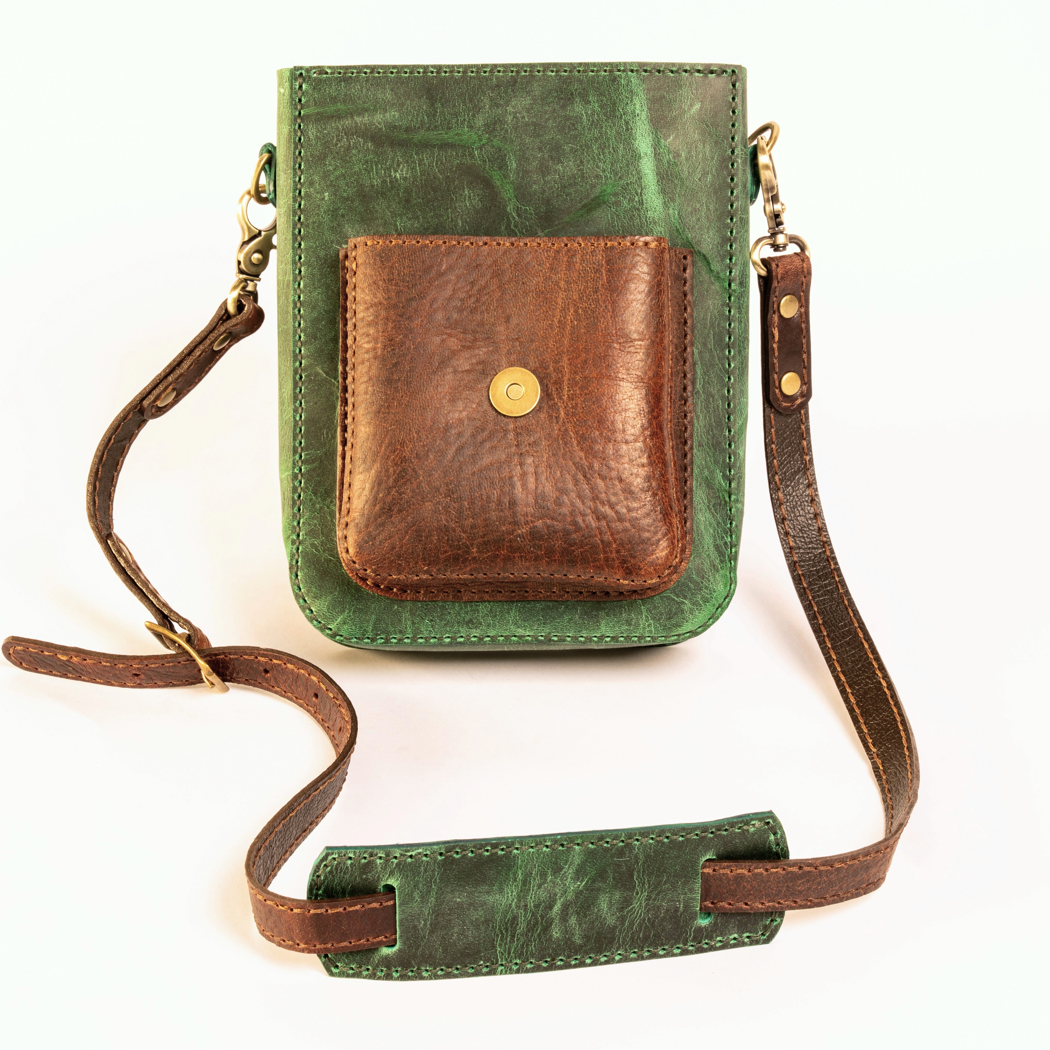 Green and brown leather crossbody bag on a white background