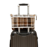 Plaid patterned bag attached to a suitcase on a white background