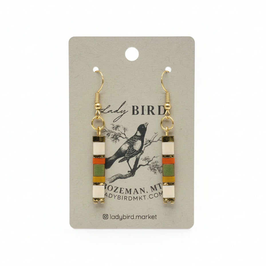 Pair of earrings on a 'Lady Bird' branded card with a bird illustration.