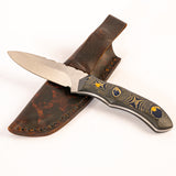 Knife with a decorative handle and leather sheath on a white background