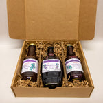 Three bottles of huckleberry gifts in a cardboard box with purple labels.