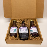 Three bottles of huckleberry gifts in a cardboard box with purple labels.