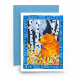 A square greeting card with a blue envelope, placed on a white surface. The card features a colorful illustration of an orange bear among birch trees and autumn leaves, surrounded by motivational text such as 'FOLLOW YOUR DREAMS' and 'ENJOY THE MOMENT • BE A FRIEND'.