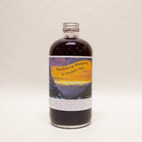 Bottle of Huckleberry Margarita & Daiquiri Mix with a scenic label on a white background