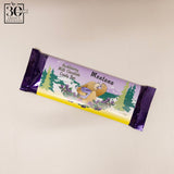 Chocolate candy bar with a purple and yellow wrapper featuring a bear and trees on a beige background.