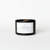 Black candle with a white label on a white surface and background