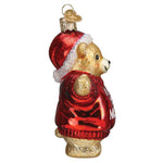 Glass ornament of a teddy bear wearing a red sweater and Santa hat on a white background