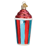 A novelty Christmas ornament shaped like a cup of iced coffee, featuring a red glittery swirl top, a red and blue striped cup with the word 'ICE' and a cartoon character, and a gold hanging loop on a white background.
