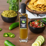 Olivelle Jalapeño Lime oil bottle surrounded by ingredients on a wooden table