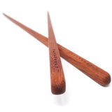 Two wooden chopsticks on a white background