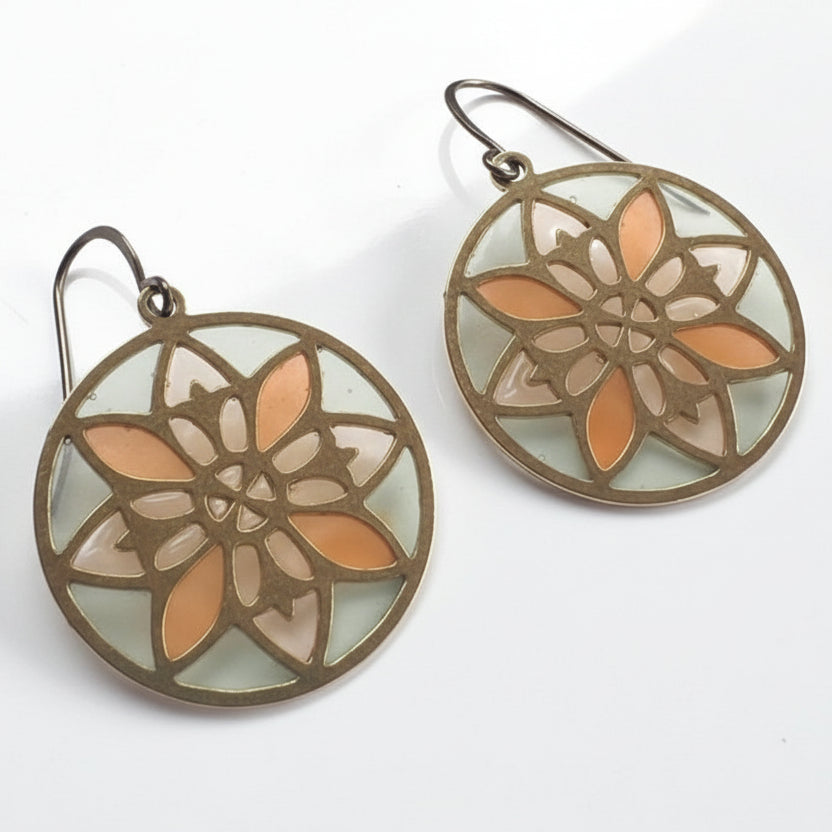 Pair of round earrings with floral design on a white surface