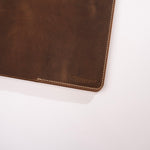 Brown leather product with visible stitching on a white background