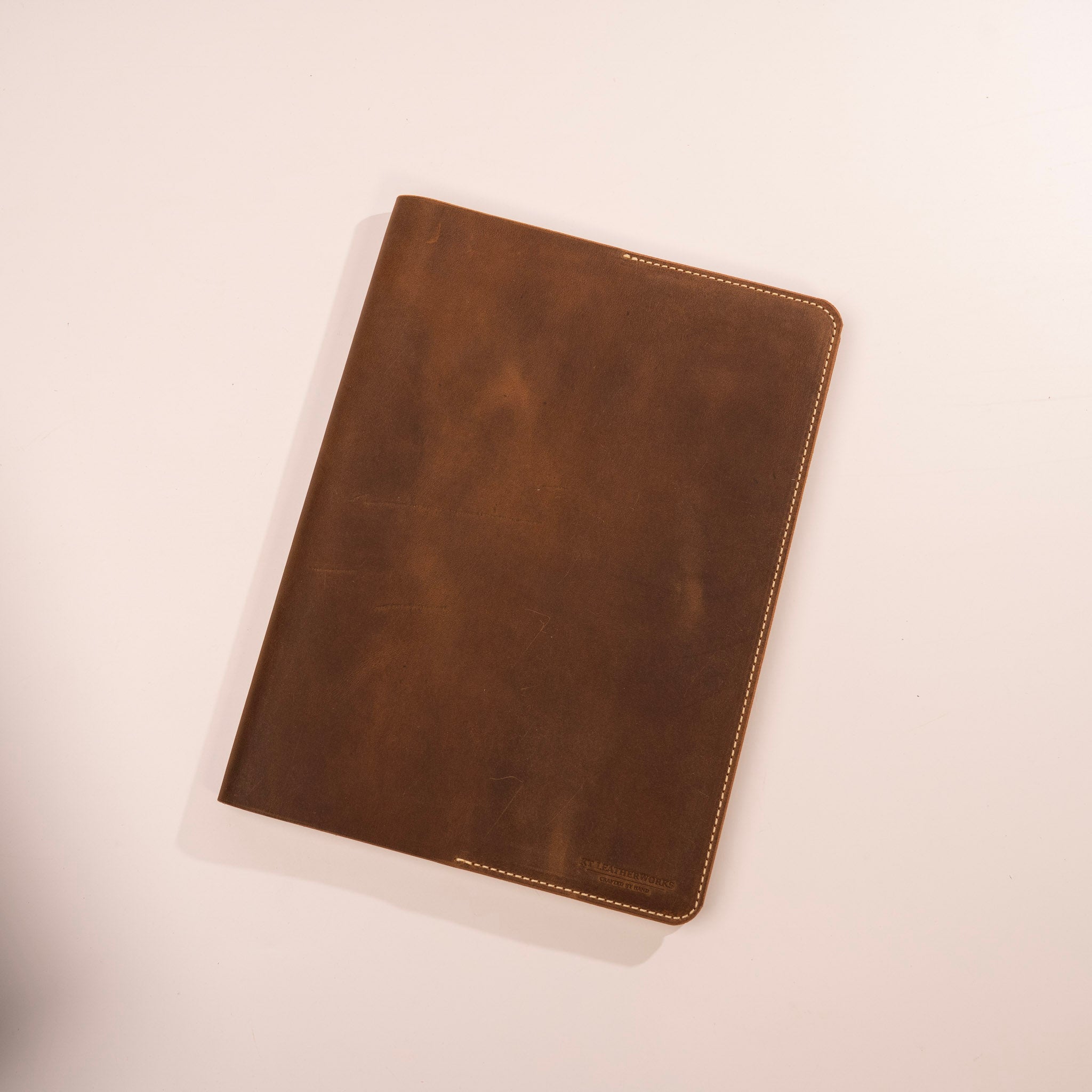 Brown leather notebook on a light beige background