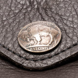 A vintage silver US five-cent coin resting on a textured dark brown leather surface.