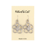 Silver flower-shaped earrings on a Nature Cast branded card.