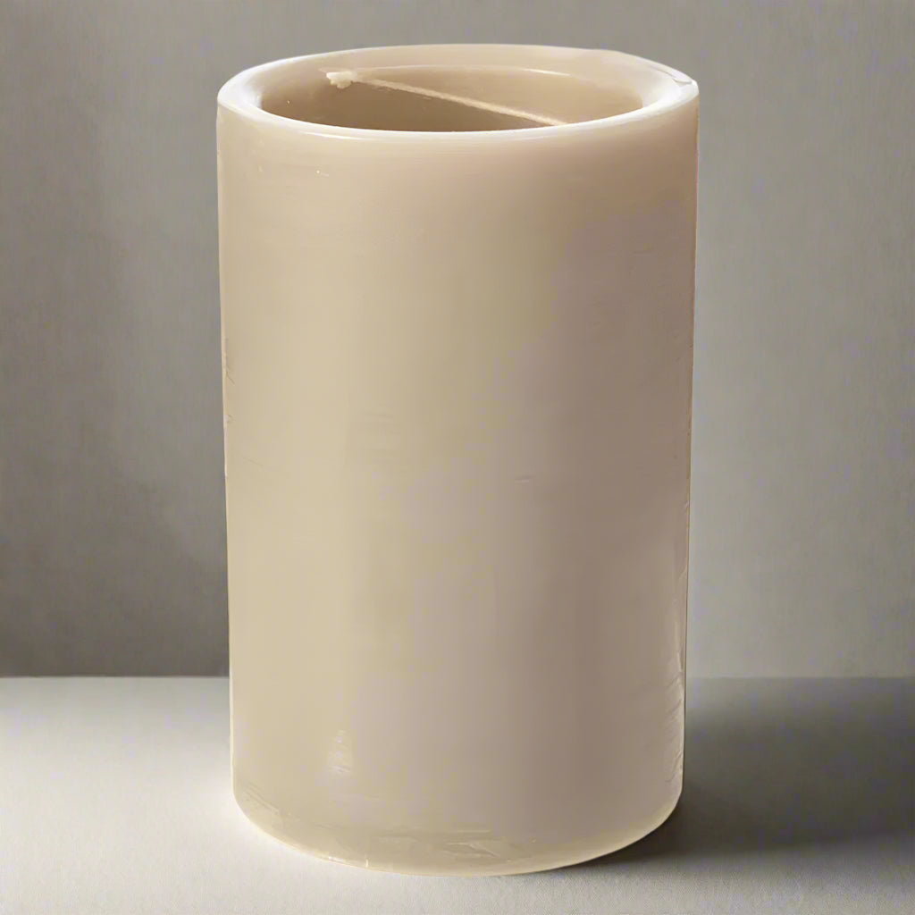 Beige candle with a wick on a white background