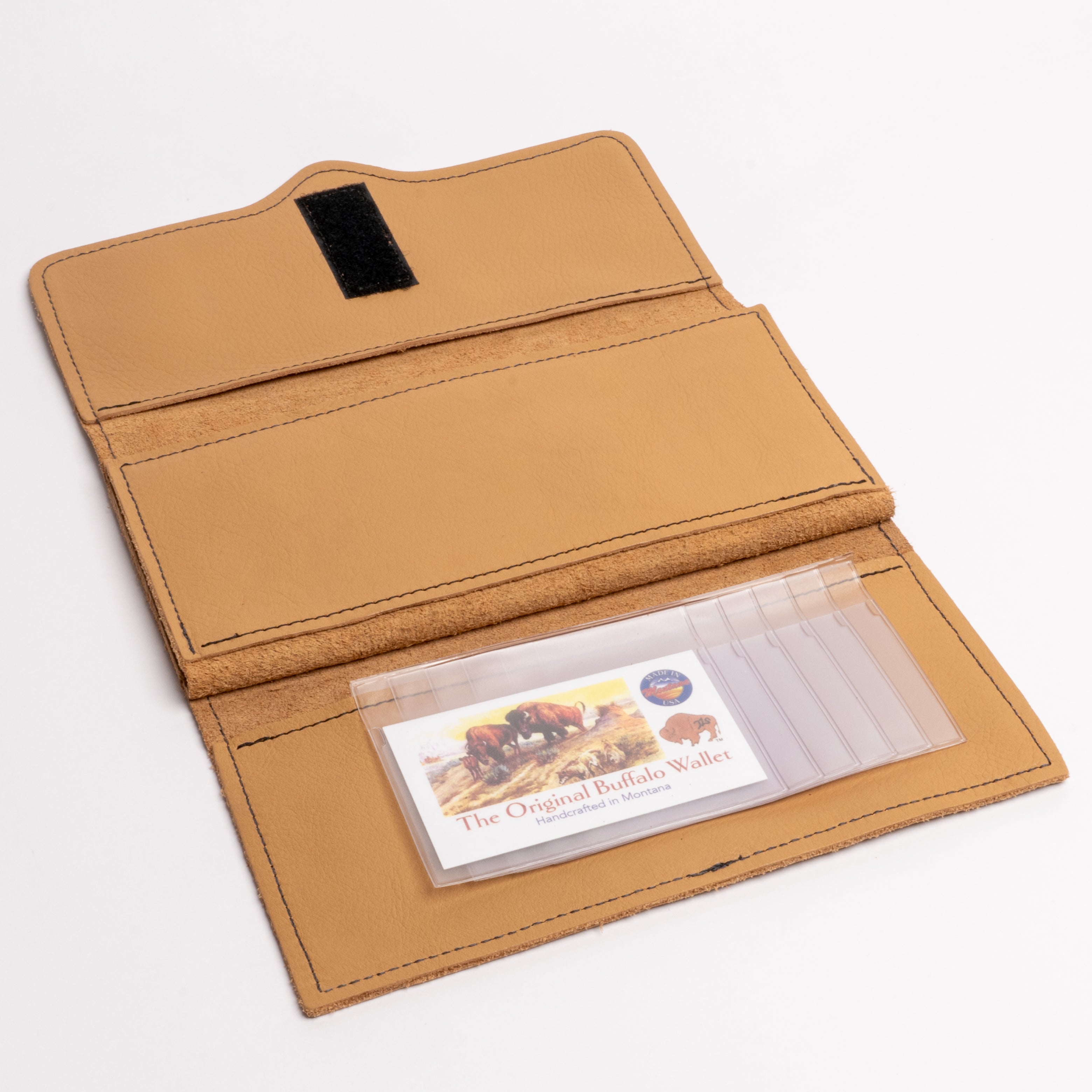 A tan leather wallet shown open on a white background, featuring multiple card slots, a black magnetic closure tab, and a clear plastic ID window holding a buffalo-themed card.