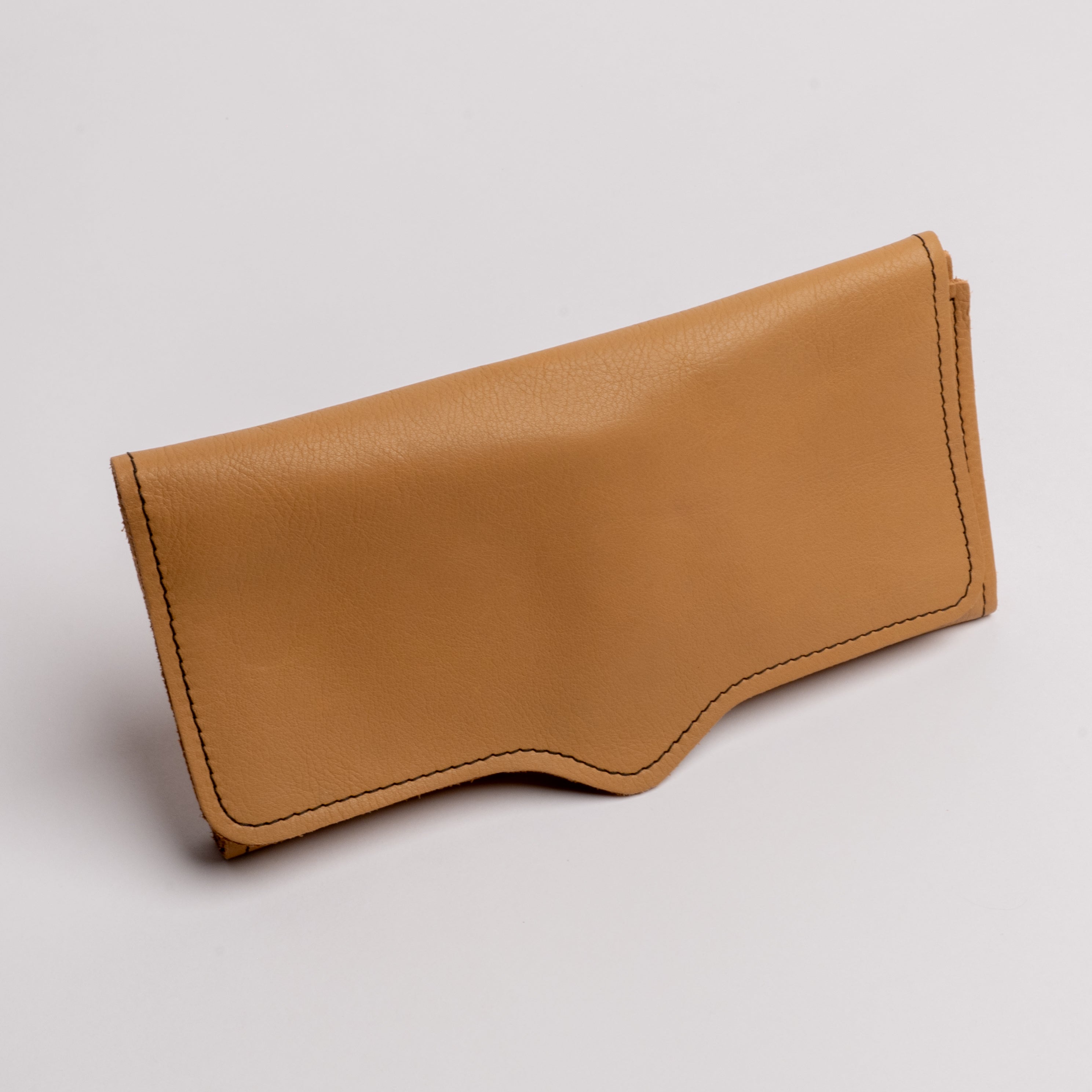 A tan leather pouch or wallet with visible stitching, photographed on a clean light gray background.